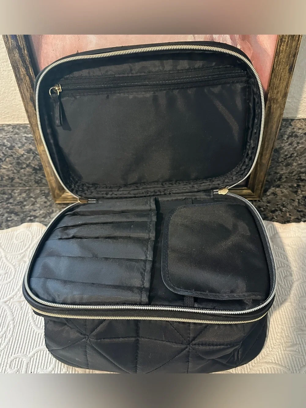 Black quilted cosmetics travel case with brush holders and pockets